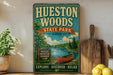 A vintage-style metal sign for Huesston Woods State Park, Ohio, featuring a canoe and a scenic landscape.