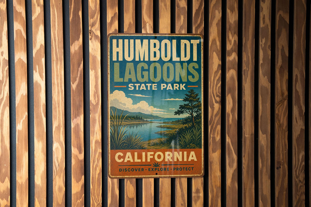 A vintage metal sign for Humboldt Lagoon State Park in California, featuring a scenic landscape with a lake, mountains, and a tree.