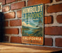 A vintage-style metal sign for Humboldt Lagoon State Park in California, featuring a scenic landscape with a lake and mountains.