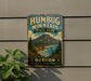 A vintage metal sign for Humbug Mountain State Park, featuring a scenic mountain landscape with pine trees, a river, and a beach.