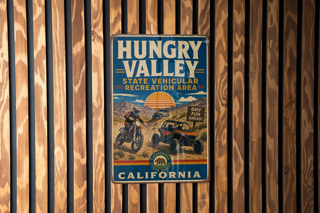 A vintage metal sign for the Hungry Valley State Vehicular Recreation Area in California, featuring an illustration of off-road vehicles and a scenic mountain landscape.