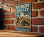A vintage-style metal sign for the "California State Recreation Area" in the "Hunky Valley", featuring an illustration of a person riding a motorcycle and a car.