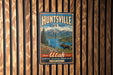 A vintage metal sign for Huntsville State Park, featuring a scenic landscape with mountains, a moose, and a lake.