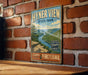 A vintage-style metal sign for Hyner View State Park in Pennsylvania, featuring a scenic mountain landscape and a river.