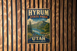 A vintage metal sign for Hyrum State Park in Utah, featuring a scenic mountain landscape with a lake and pine trees.