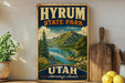 A vintage-style sign for Hyrium State Park in Utah, featuring a scenic mountain landscape with a lake and pine trees.