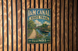 A vintage-style metal sign for the I&M Canal State Trail in Illinois, featuring a scenic illustration of a canal and surrounding landscape.