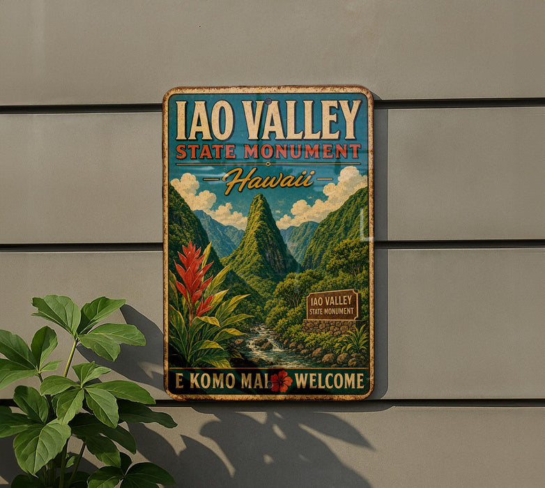 A vintage-style metal sign for the Iao Valley State Monument in Hawaii, featuring a mountainous landscape with a waterfall and tropical plants.
