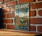 A vintage-style sign for Icelandic State Park in North Dakota, featuring a scenic landscape with mountains, water, and a Viking ship.