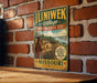 A vintage-style sign for the Iliniewek Village State Historic Site in Missouri, featuring a painting of a Native American village.