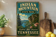 A vintage-style metal sign for Indian Mountain State Park in Tennessee, featuring a scenic landscape with mountains, trees, and a river.