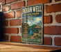 A vintage-style metal sign for Indian Well State Park in Connecticut, featuring a scenic illustration of the park's natural surroundings.