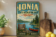 A vintage-style sign for the Ionia State Recreation Area in Michigan, featuring a scenic image of a lake, pine trees, and a canoe.