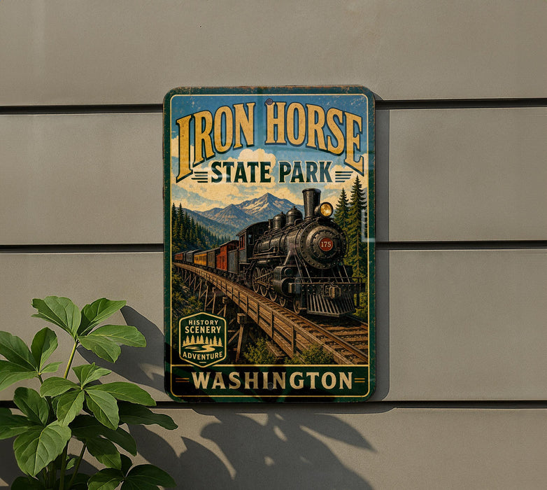 A vintage-style metal sign for Iron Horse State Park in Washington, featuring a train on a track and a scenic mountain landscape.