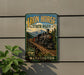 A vintage-style metal sign for Iron Horse State Park in Washington, featuring a train on a track and a scenic mountain landscape.
