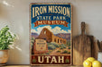a vintage-style sign for the Iron Mission State Park Museum in Utah, with a desert landscape and a sign that reads "Iron Mission Est. 1864".