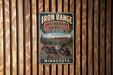 A vintage metal sign for the Iron Range Off-Highway Vehicle State Recreation Area in Minnesota, featuring an illustration of an ATV and a person riding it.