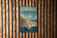 A vintage metal sign for Island Beach State Park in New Jersey, featuring a beach scene with a lighthouse and birds, mounted on a wooden wall.
