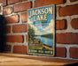 A vintage-style metal sign for Jackson Lake State Park in Ohio, featuring a scenic image of the lake and surrounding landscape.