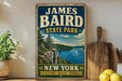 A vintage-style sign for James Baird State Park in New York, featuring a scenic landscape with a lake, mountains, and a sailboat.