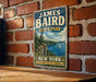 A vintage-style metal sign for James Baird State Park in New York, featuring a scenic landscape with a lake, mountains, and a sailboat.