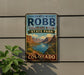 A vintage-style sign for James M. Robb Colorado River State Park, featuring a scenic landscape with mountains, a river, and a cloudy sky.
