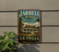 A vintage-style sign for the Jarrell Plantation State Historic Site in Georgia, featuring a house and palm trees.