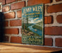 A vintage-style metal sign for Jenny Wiley State Resort Park in Kentucky, featuring a scenic image of a river and mountains.