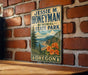 A vintage-style metal sign for Jessie M. Honeyman Memorial State Park in Oregon, featuring a scenic landscape with pine trees, mountains, and a river.