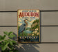 A vintage-style metal sign for John James Audubon State Park in Kentucky, featuring a blue heron and a scenic landscape.