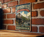 A vintage-style metal sign for Johnsonville State Historic Park in Tennessee, featuring a scenic illustration of a historic building and a waterfall.