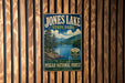 A vintage-style metal sign for Jones Lake State Park, featuring a scenic landscape with pine trees, mountains, and a lake.