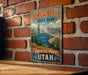 A vintage-style metal sign for Jordanelle State Park in Utah, featuring a scenic mountain landscape with a lake and pine trees.