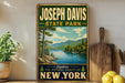 A vintage-style sign for Joseph Davis State Park, featuring a scenic landscape with mountains, pine trees, and a lake.