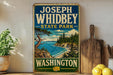 A vintage-style sign for Joseph Whidbey State Park in Washington, featuring a scenic landscape with pine trees, a body of water, and a rocky cliff.