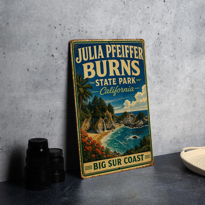 A vintage-style metal sign for Julia Pfeiffer Burns State Park in California, featuring a scenic coastal landscape with a beach, mountains, and a waterfall.
