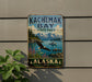 A vintage-style metal sign for Kachmak Bay State Park in Alaska, featuring a scenic landscape with mountains, a lake, and a bald eagle in flight.
