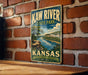 A vintage metal sign for Kaw River State Park in Kansas, featuring a scenic illustration of the park's natural and historical attractions.