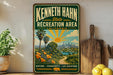 A vintage-style sign for the Kenneth Hahn State Recreation Area in California, featuring a scenic landscape with palm trees, a sun, and a city skyline.