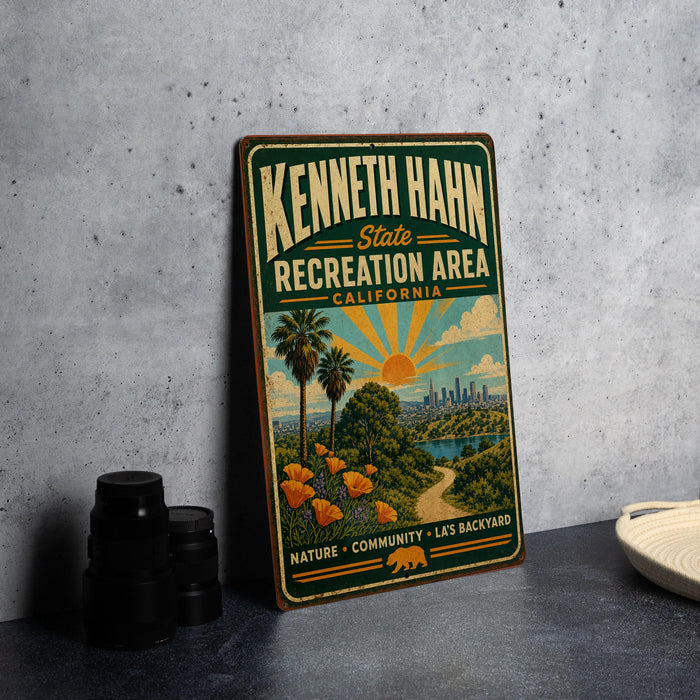 A vintage-style sign for the Kenneth Hahn State Recreation Area in California, featuring a scenic illustration of a beach, palm trees, and a city skyline.