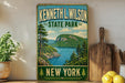 A vintage-style sign for Kenneth L. Wilson State Park in New York, featuring a scenic landscape with a lake and mountains.