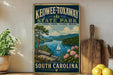 A vintage-style sign for Keowee-Toxaway State Park, featuring a scenic landscape with a lake, mountains, and a sailboat.