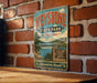 A vintage-style metal sign for "Keystone State Park, Oklahoma" is displayed on a brick wall, featuring a scenic illustration of a lake and bridge.
