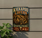 A vintage-style sign for the Kickapoo Cave State Park in Texas, featuring an illustration of the cave system.