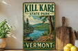 A vintage-style sign for Kill Kare State Park in Vermont, featuring a scenic landscape with a lake and mountains.