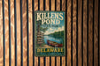 A vintage metal sign for Killens Pond State Park in Delaware, featuring a canoe on a lake and text promoting the park's recreational activities.