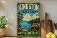 A vintage-style sign for Kingston State Park in New Hampshire, featuring a scenic landscape with a lake and mountains.