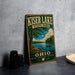 A vintage-style metal sign for Kiser Lake State Park in Ohio, featuring a scenic landscape with a lake, trees, and boats.