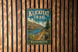 A metal sign with the text "Klickitat Trail State Park Washington" is displayed on a wooden wall.