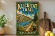 A vintage-style metal sign for Klickitat Trail, State Park in Washington, featuring a scenic mountain landscape with a river and trail marker.